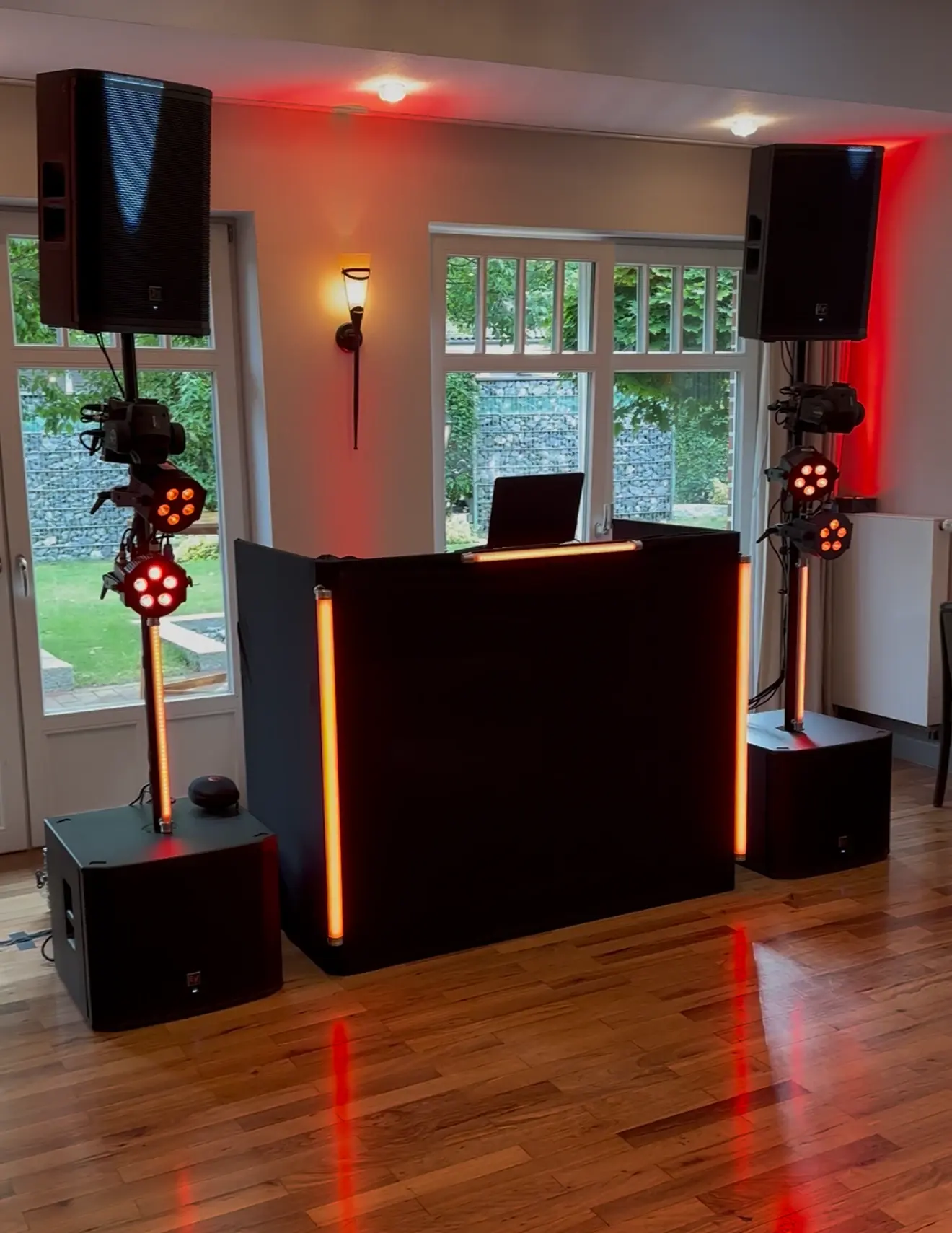 Aufgebautes DJ-Setup mit Electro-Voice-Boxen auf Stativen und rotem Licht