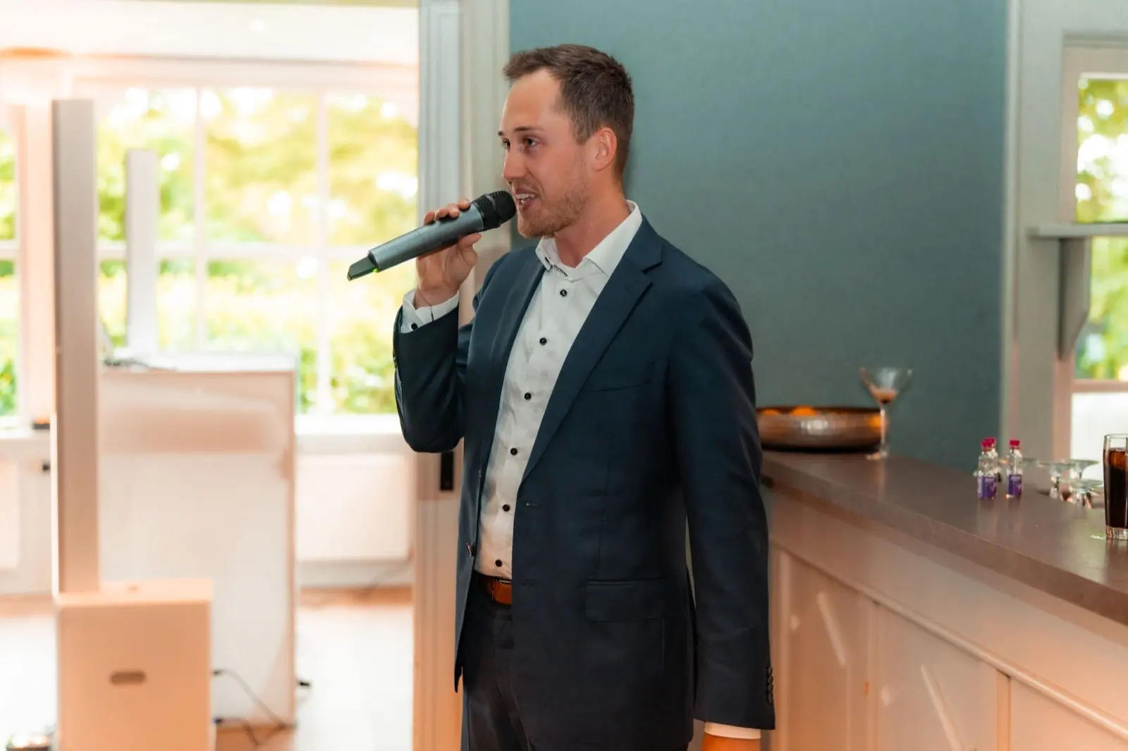 Marvin moderiert mit Mikrofon auf einer Feier